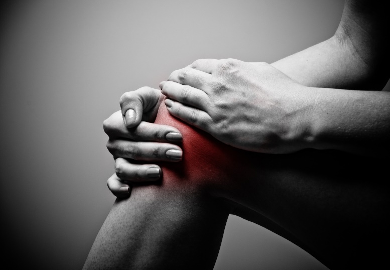 A person holding a painful knee.