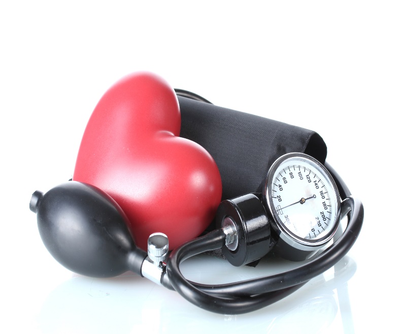 Blood pressure cuff and gauge beside a heart-shaped object.